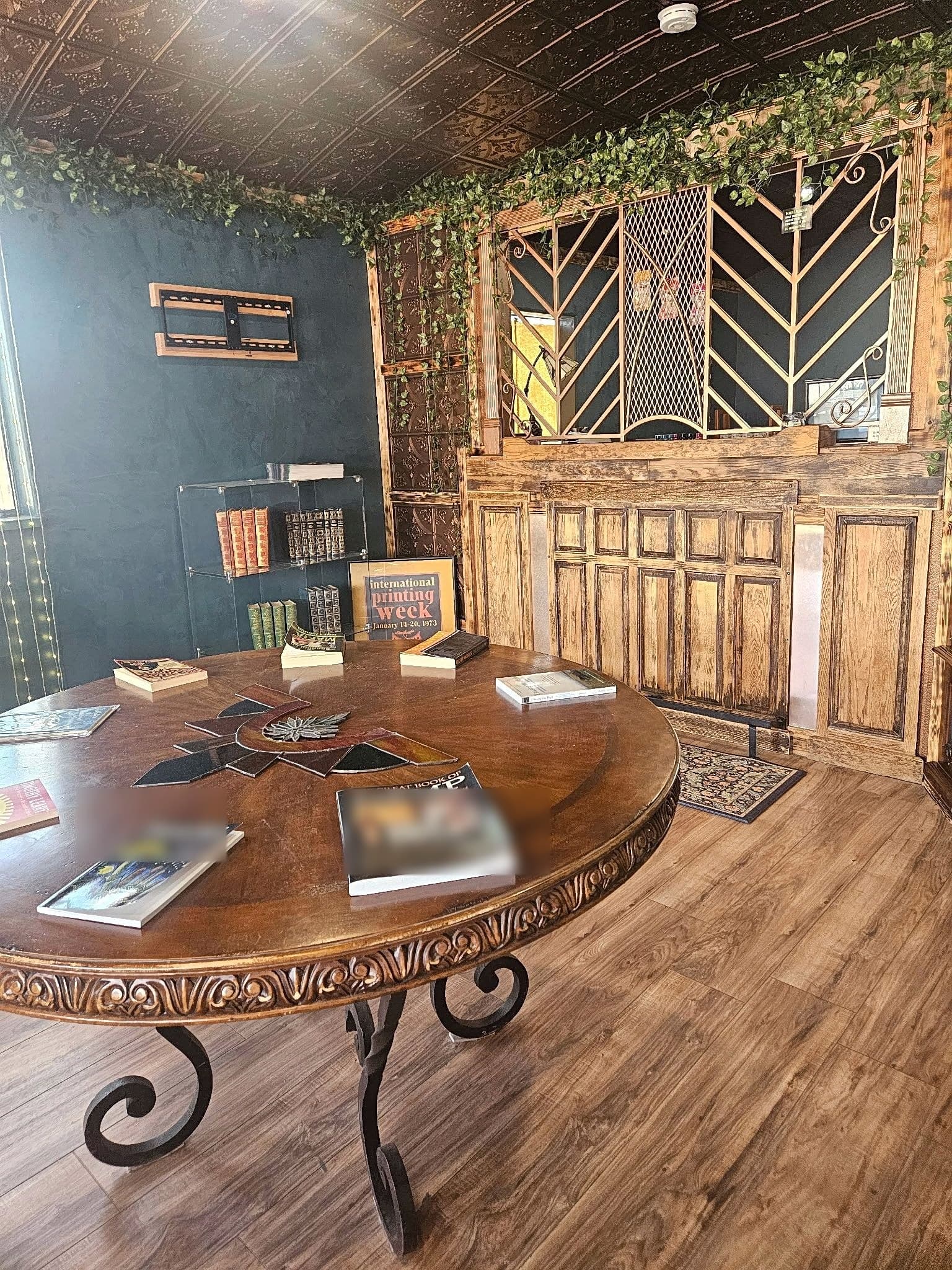 Reading table with books, tin ceiling, and teller counter inside Weed and Read